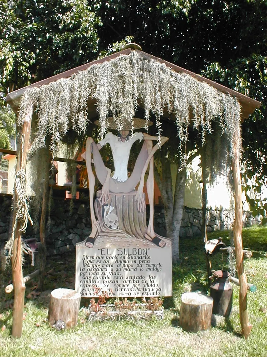 A tall figure of El Silbón with a hat and a sack over his shoulder, displayed at a folklore theme park in Mérida, Venezuela.