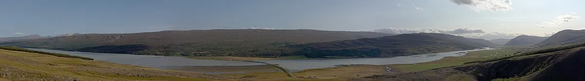 The broad, grey waters of Lagarfljót with the forest of Hallormsstaður on the far bank in East Iceland.