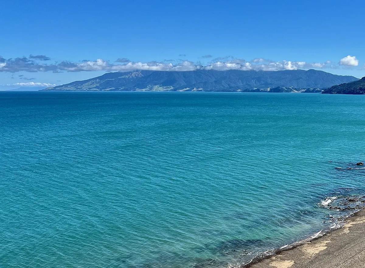 The bush-covered Moehau Range seen across the water from south of Amodeo Bay, Coromandel
