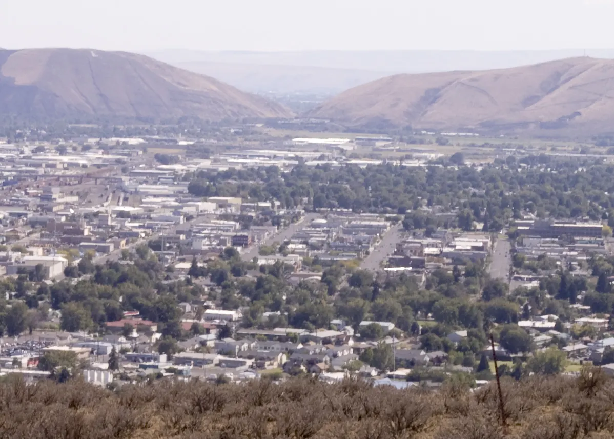 View over the city of Yakima, Washington, toward Union Gap and brown hills under a blue sky
