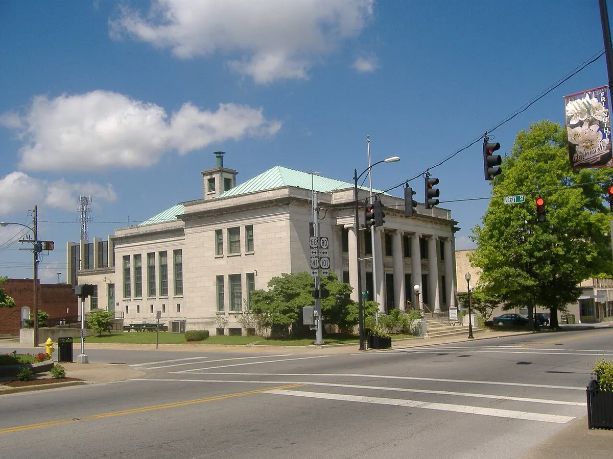 A pale stone neoclassical building with columns on a street corner in downtown Hopkinsville, Kentucky